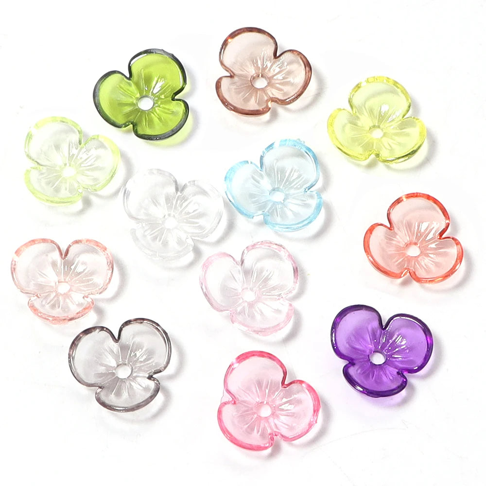 A collection of colorful resin flower bead caps in shades of green, pink, yellow, and purple for jewelry making.