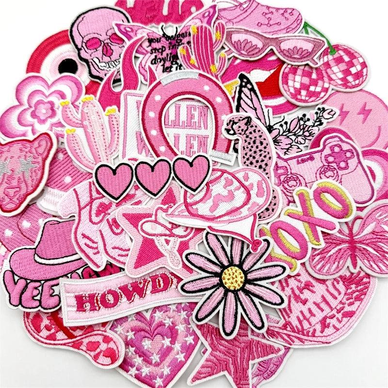 A collection of pink embroidered applique patches featuring various floral, skull, and decorative designs for DIY projects.