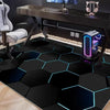 A black hexagon gaming area rug with glowing blue neon accents placed on a dark wooden desk.