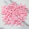 A pile of small pink satin ribbon bows for crafts and decor