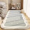 A rectangular light gray rug with white geometric patterns and dots placed on a wooden floor.