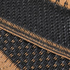 Close-up of a black and tan plastic straw mat with woven texture and visible stitching.