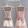 A floral pattern household kitchen cooking apron displayed on a wooden hanger.