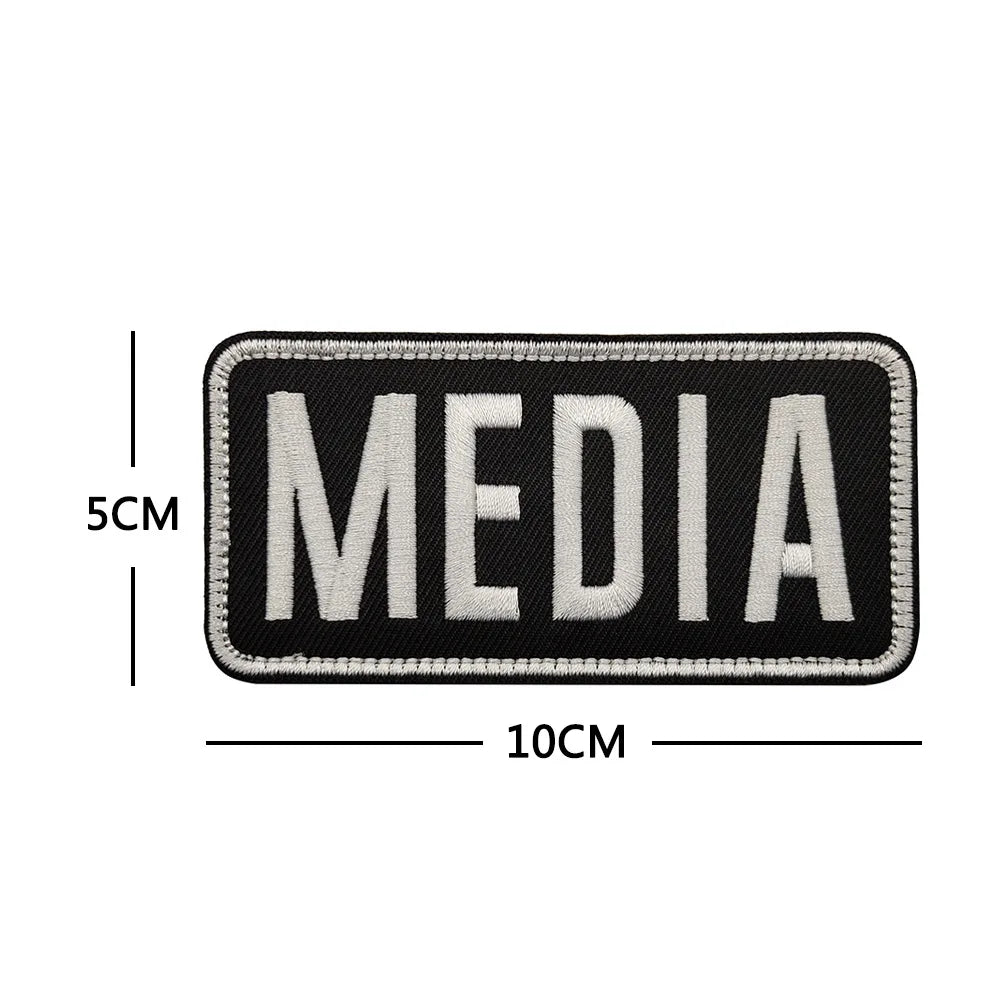 Black embroidered patch with the word MEDIA in light gray text and a hook and loop backing.