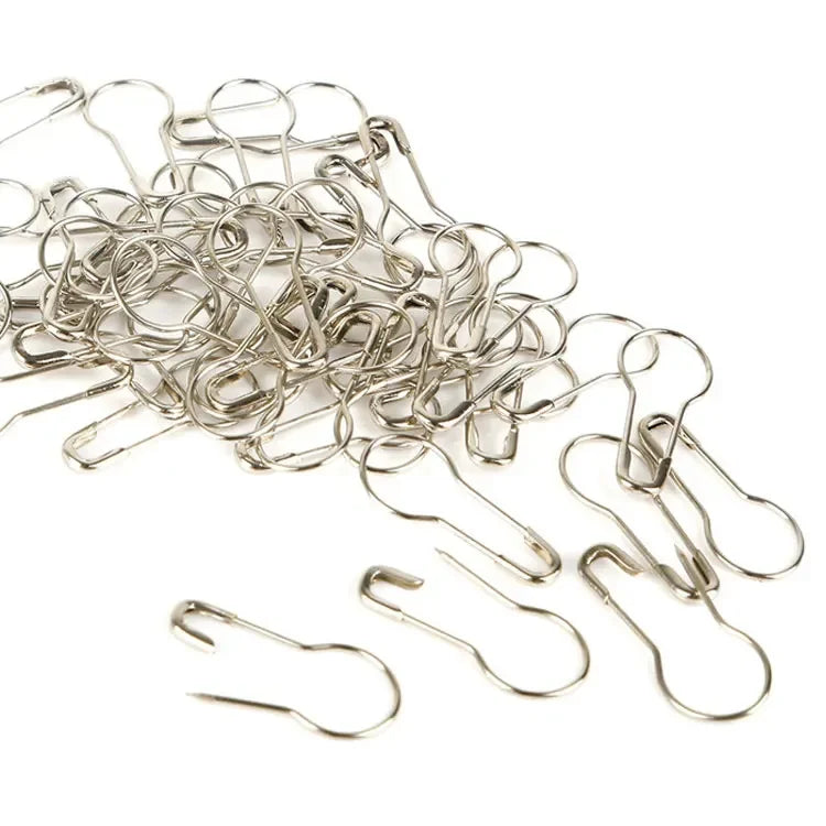 A pile of silver safety bulb pins for knitting and sewing.