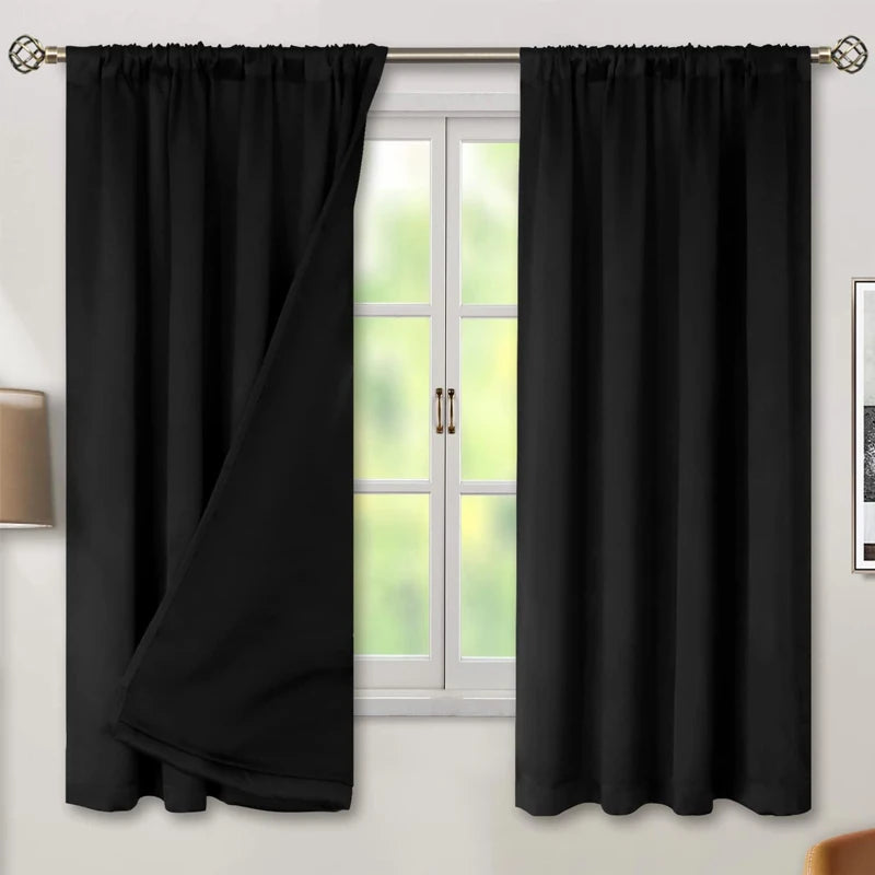 Black waterproof thermal blackout curtain panel hanging on a window