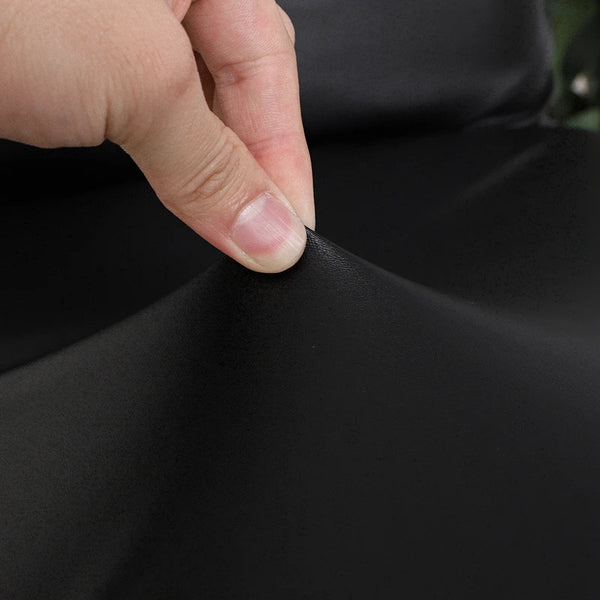 A hand is touching the fabric of a black waterproof stretch dining bench cover.