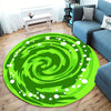 A vibrant green swirl round area rug placed on a wooden floor next to a gray sofa.