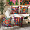 A collection of four colorful boho chic mandala plaid pillow covers displayed on a white sofa.