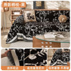Black floral patterned chenille sofa slipcover displayed on a wooden frame.