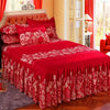A set of three red and white floral patterned fitted bed sheets displayed on a bed with pink headboard.