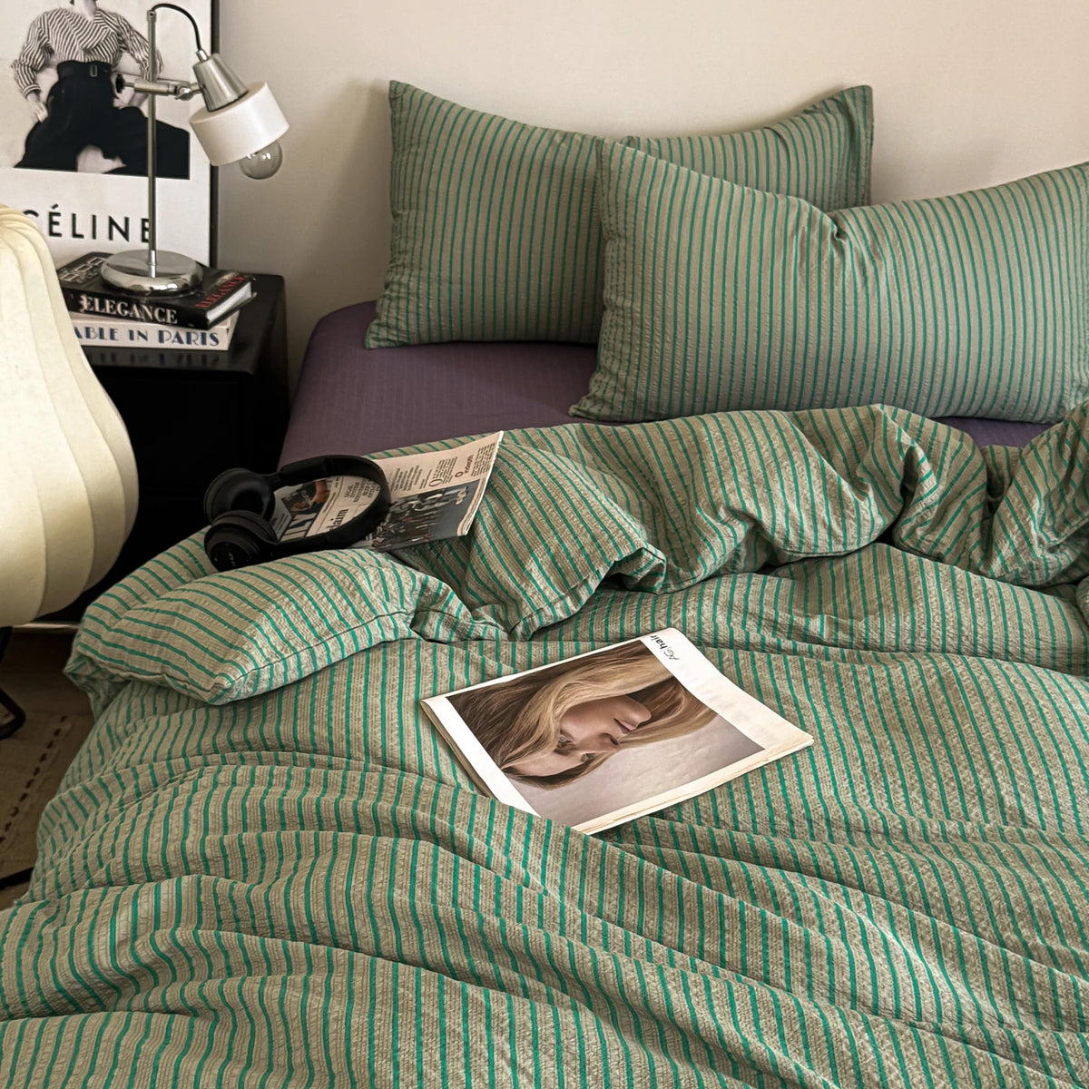 A green and striped duvet cover set with matching pillows on a bed.
