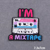 Black embroidery patch with pink and blue text reading I'M A MIXTAPE