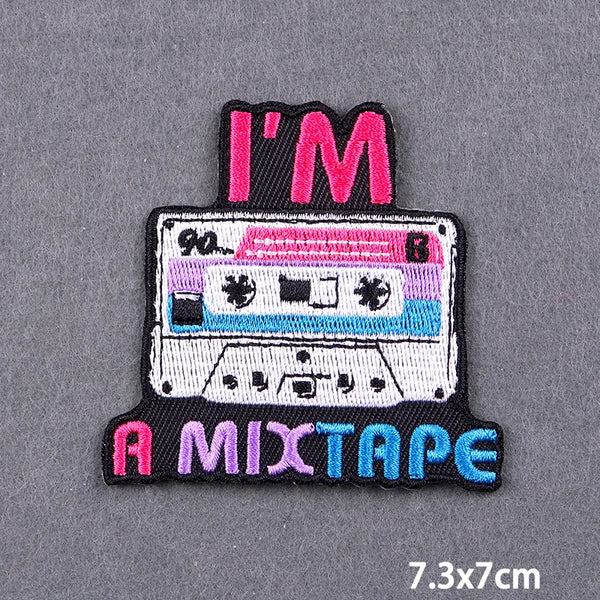 Black embroidery patch with pink and blue text reading I'M A MIXTAPE