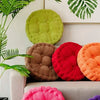 A collection of tufted corduroy floor seat cushions in various colors including green, brown, red, and orange.