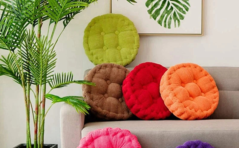 A collection of tufted corduroy floor seat cushions in various colors including green, brown, red, and orange.