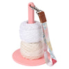 A pink adjustable yarn holder and winder set with a white yarn ball and leather strap.