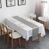 A white satin table runner with a gray accent is displayed on a long table set for an event.