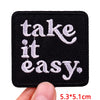 Black embroidered patch with white text that reads take it it easy