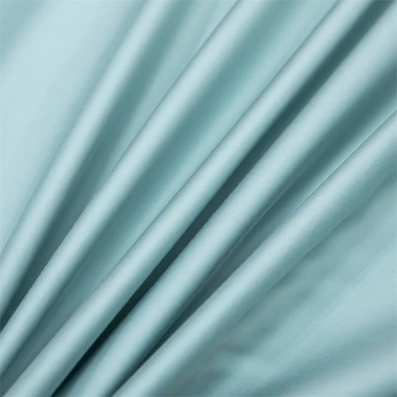 Soft mint green bamboo flat sheets draped and folded to show fabric texture