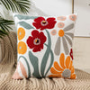 A throw pillow cover featuring embroidered red and orange floral designs on a white background.