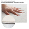 A hand is touching a white, thick suede non-slip mat on a light surface.