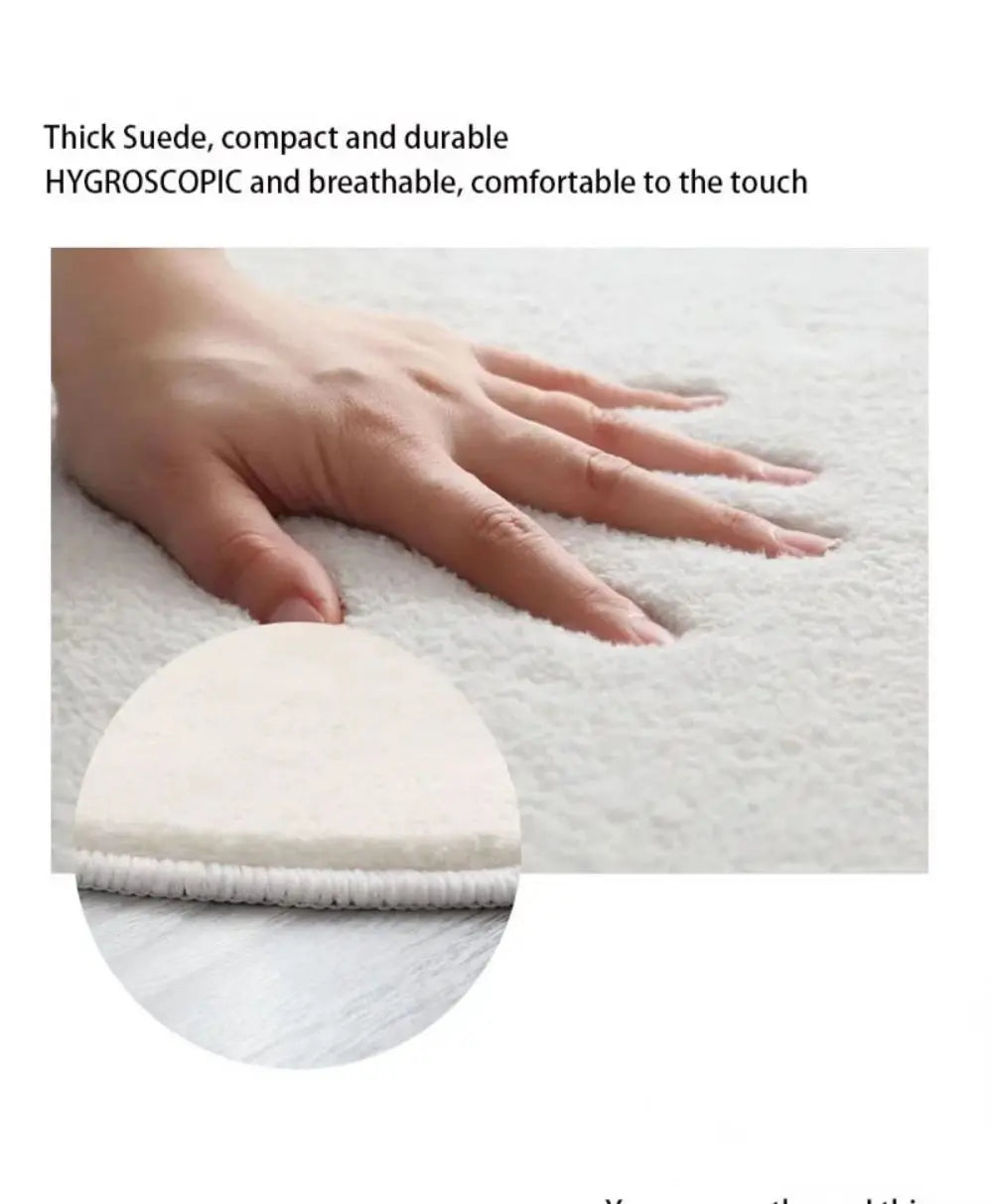 A hand is touching a white, thick suede non-slip mat on a light surface.