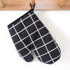 A pair of black and white checkered heat-resistant kitchen oven gloves hanging on a wooden rack.