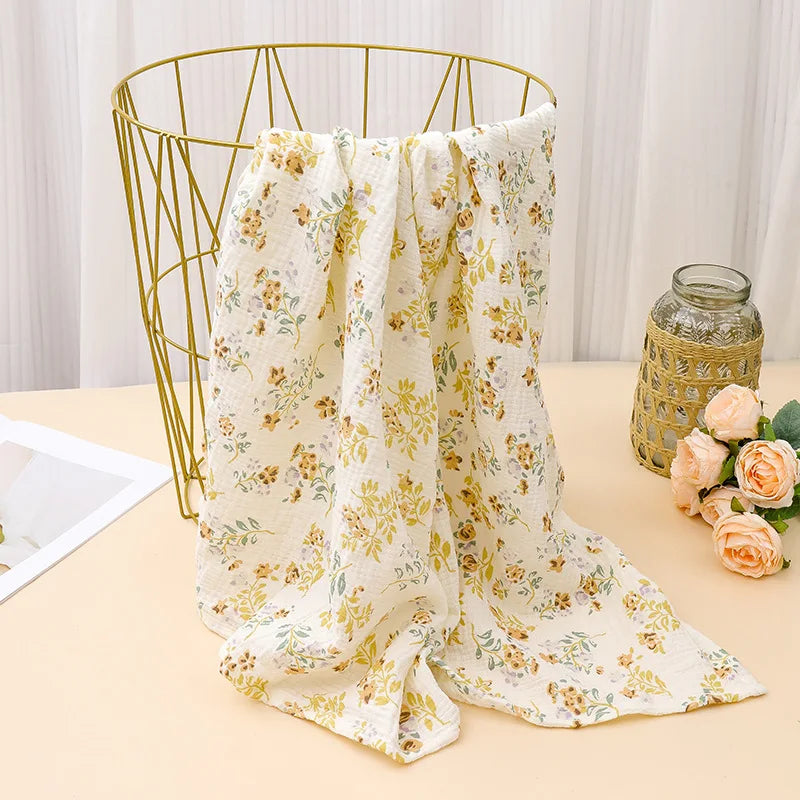 A cream floral patterned fabric draped over a gold wire hanger, displayed next to a glass jar.