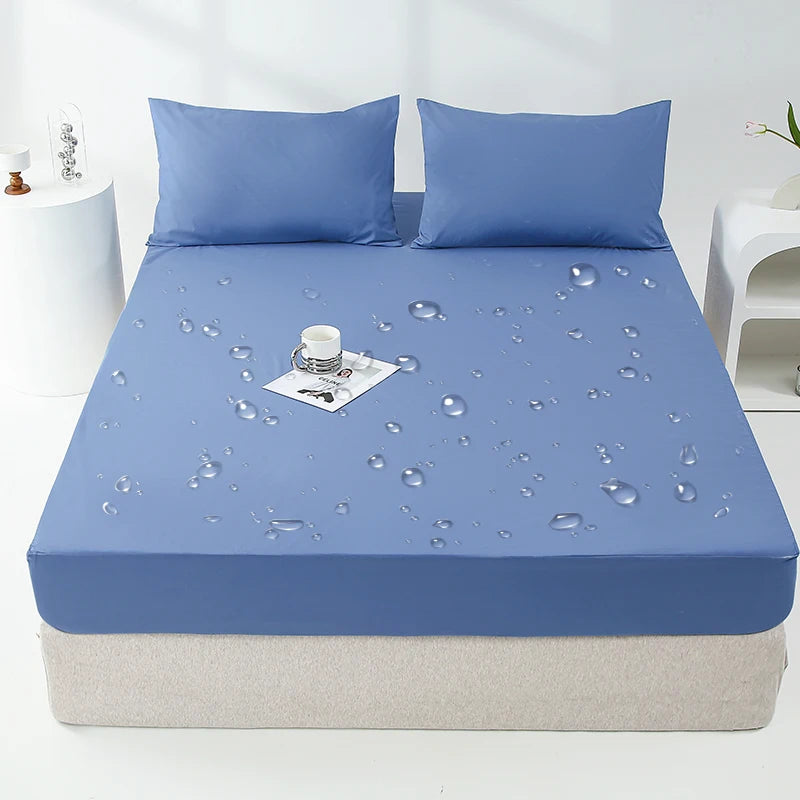 A light blue waterproof mattress and bed protector sheet is laid over a mattress with matching pillows.