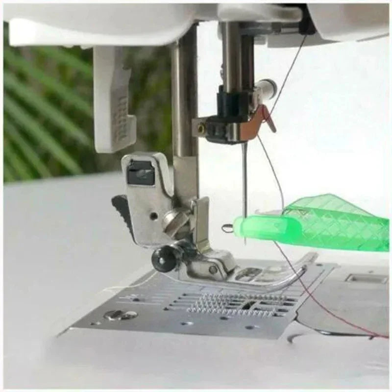 A close-up of a mini hand sewing needle threader kit being used on a piece of fabric.
