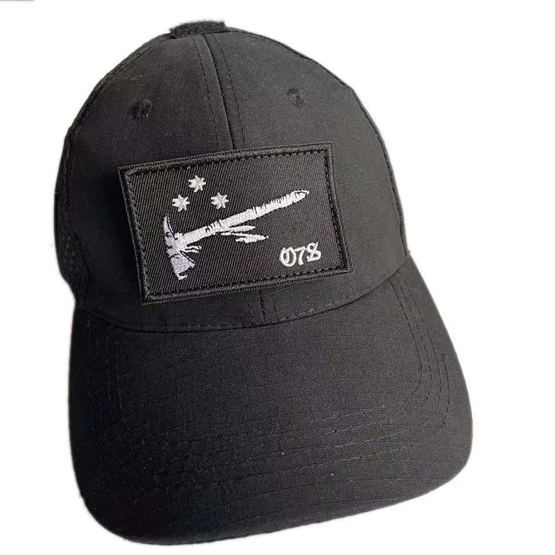 Black baseball cap with an embroidered pirate flag patch featuring a hook and loop backing