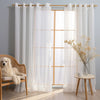 White sheer tulle window curtains hanging on a rod in a bright room with natural light.