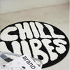 Black and white fuzzy round letter pattern floor mat with a brand tag