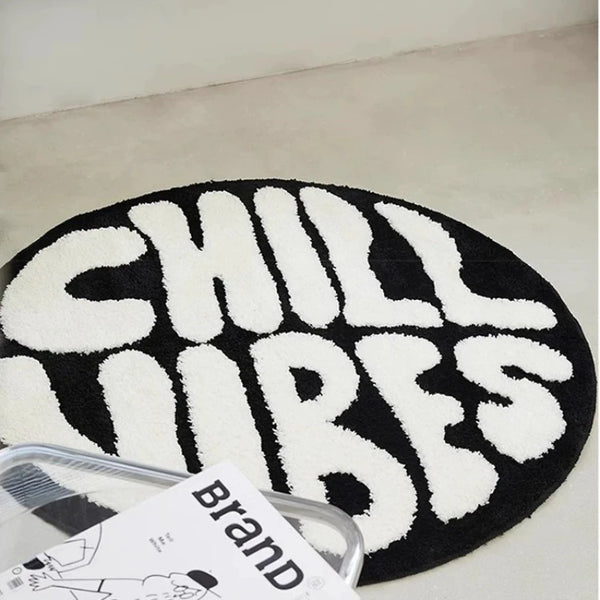 Black and white fuzzy round letter pattern floor mat with a brand tag
