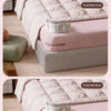 A pink bed sheet is secured to a pink mattress cover using invisible clips, shown in close-up.