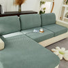 A light sage green jacquard knit sofa cushion cover on a modern sectional sofa.