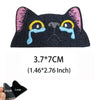 Black cat embroidered patch with pink and yellow accents featuring tear-like eyes