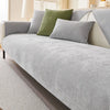 A light gray chenille sofa cushion cover with olive green and gray accent pillows on a modern sofa.