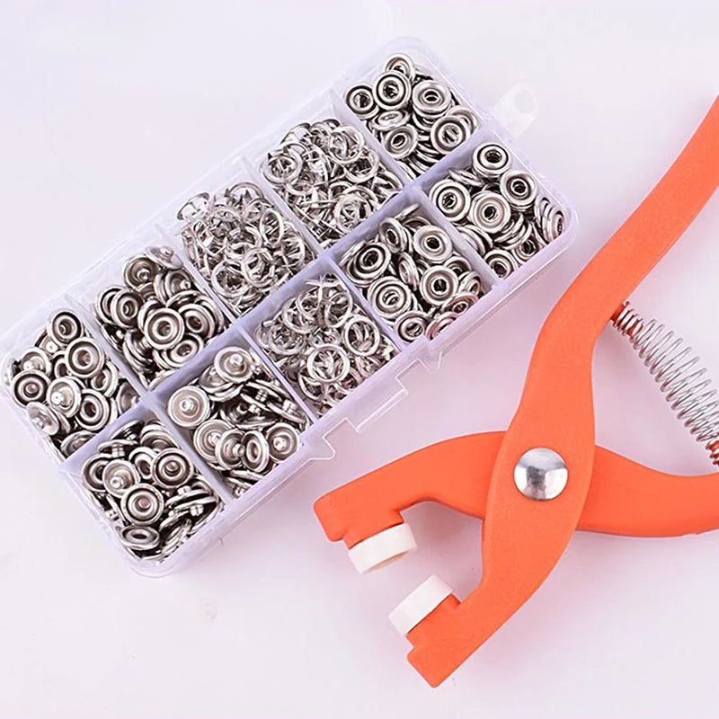 A clear plastic kit containing metal snap buttons and pliers for DIY sewing crafts.