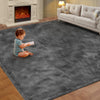 A gray ultra-soft plush living room rug with a toddler sitting on it in a well-lit room.