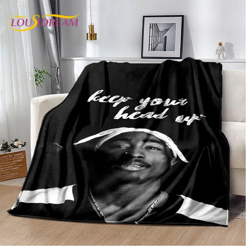 A black throw blanket featuring a black and white portrait of a man with a headband and the text keep your head up