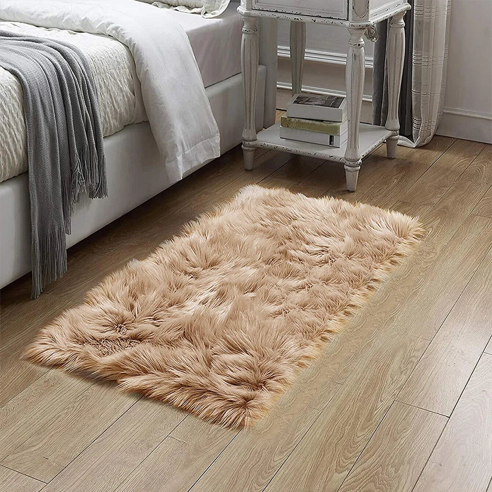 A fluffy, light brown silk wool floor rug placed on a wooden floor next to a white bed and antique cabinet.