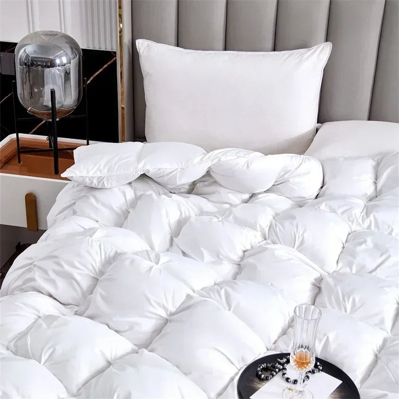 White luxury goose down quilt duvet with fluffy pillows on a bed