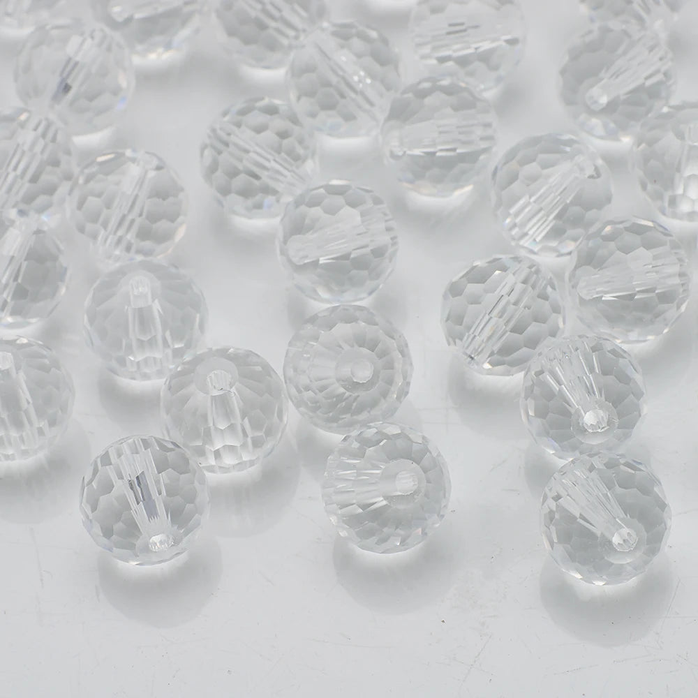 A close-up view of clear, faceted glass beads in various sizes and shapes for jewelry making.
