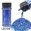 A glass bottle of blue holographic glitter mix with a black cap and a pile of loose glitter.