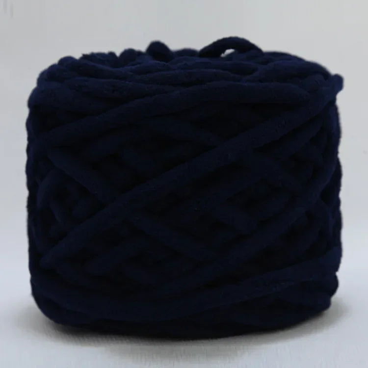 A ball of dark navy blue chenille knitting yarn used for hand crafting.