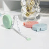 A set of pink and blue retractable double-sided measurement tapes are displayed next to a ruler.