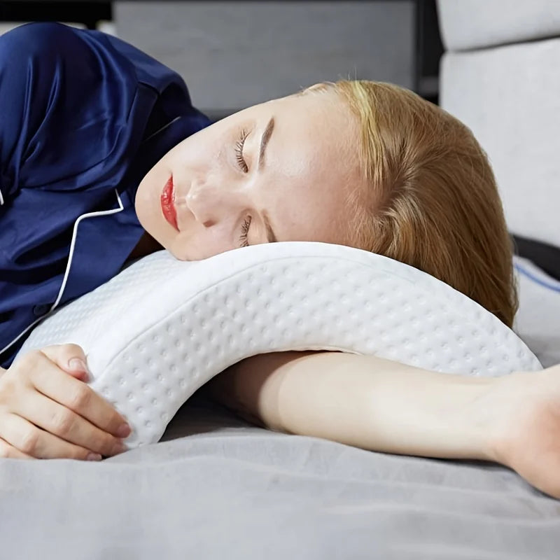A young woman is resting with an arched memory foam cuddle pillow supporting her neck and head.