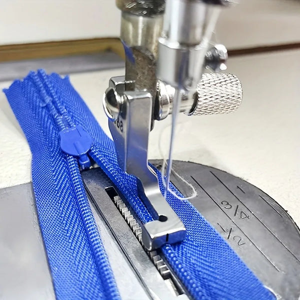 A close-up view of an industrial steel presser foot with an invisible zipper being used for sewing.